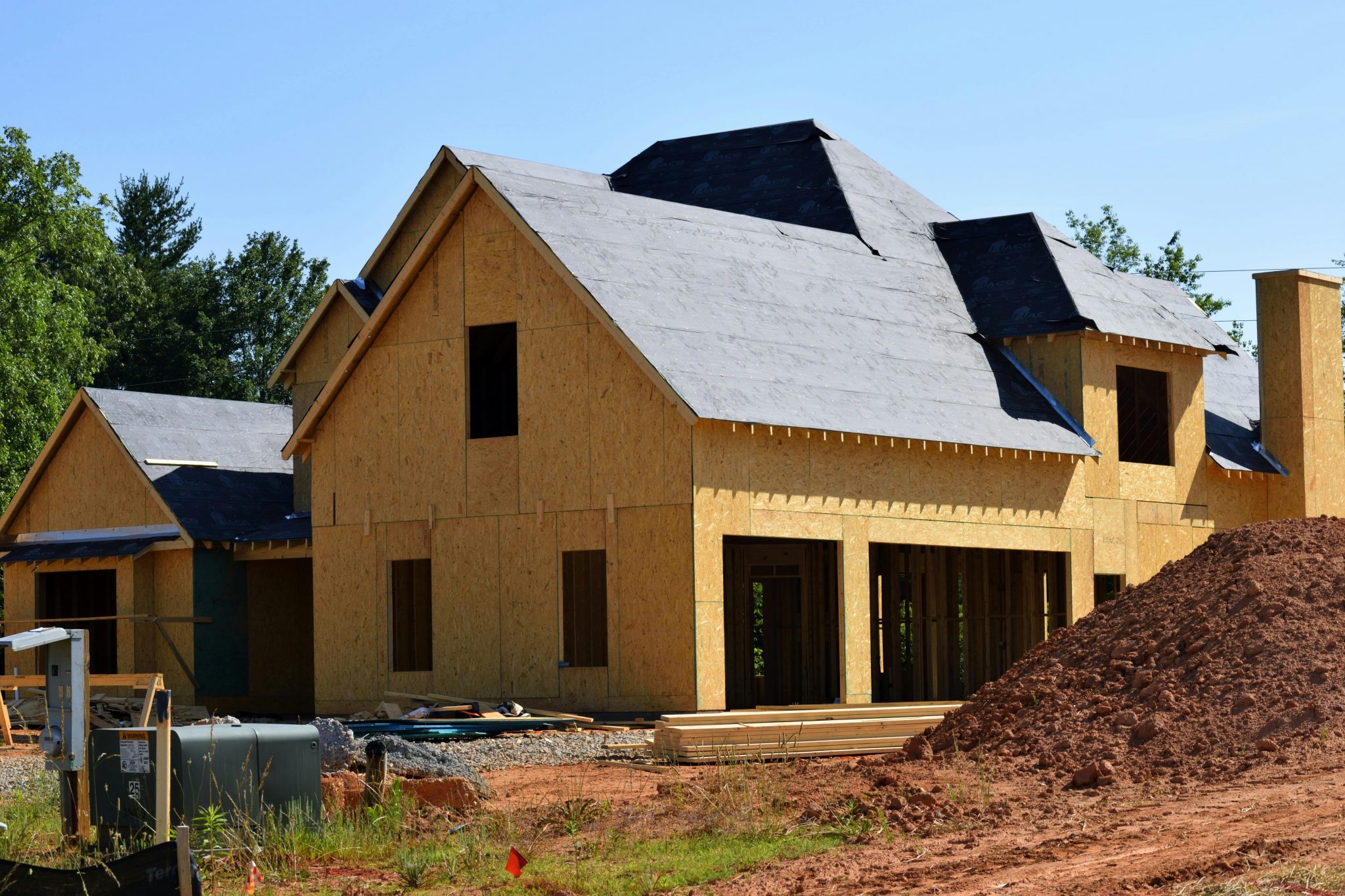 New construction home in Las Vegas during the framing stage, showing wooden beams and framework being assembled.